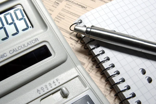 Taschenrechner mit Ziffern auf dem Display, Stift und Notizbuch auf n — Stockfoto