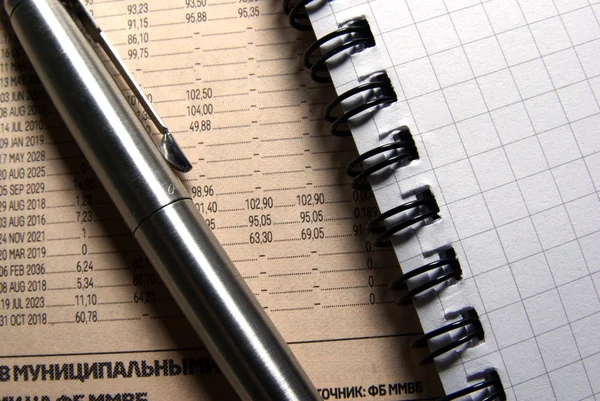 Stalen pen en notebbok op krant close-up. bedrijfsconcept. — Stockfoto