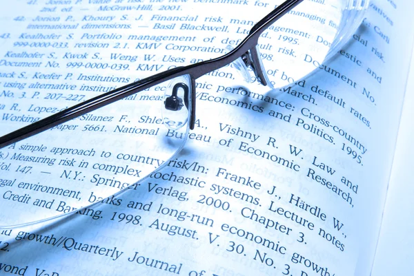 Glasses laying on financial book. — Stock Photo, Image