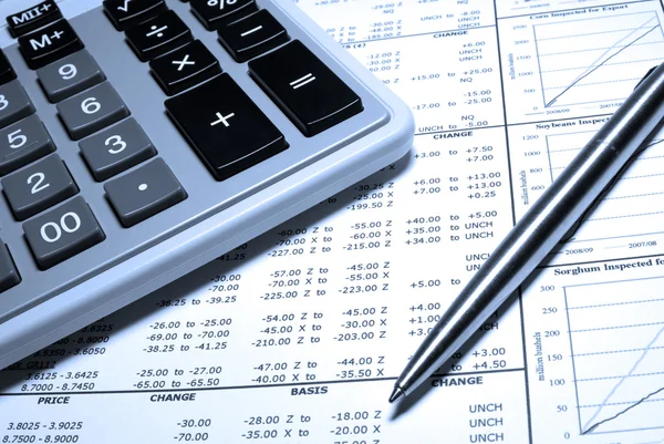 Kalkulačka, ocelové pero a finanční údaje s grafy. — Stock fotografie