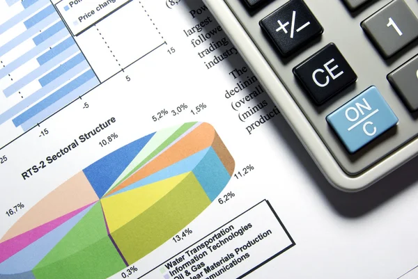 Calculator and printed stock data with diagrams. — Stock Photo, Image