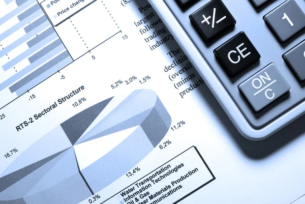 Calculator and printed stock data with diagrams. — Stock Photo, Image