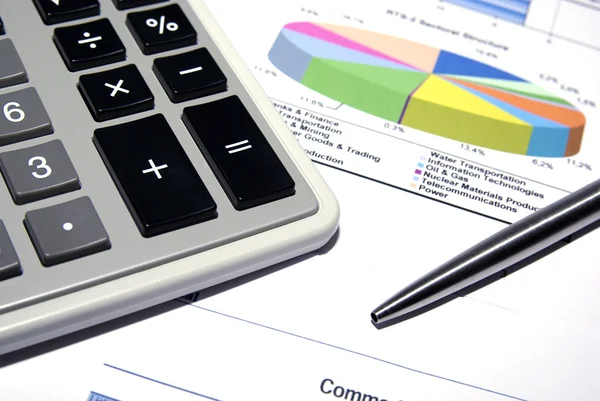 Kalkulačka a ocelové pero na tištěné finanční údaje. — Stock fotografie