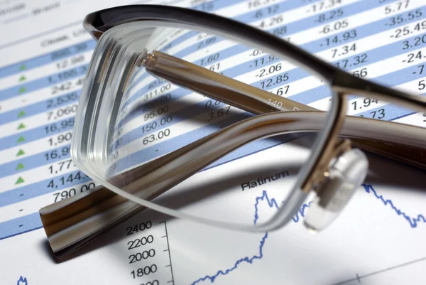 Glasses laying on printed financial report. Some graphs and data — Stock Photo, Image