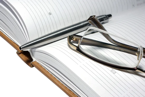 Ocelové pero, brýle a agenda. — Stock fotografie