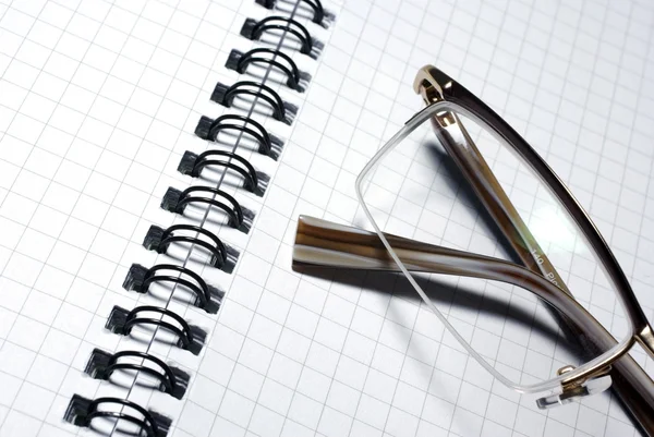 Glasses laying on spiral notebook. Business concept. — Stock Photo, Image
