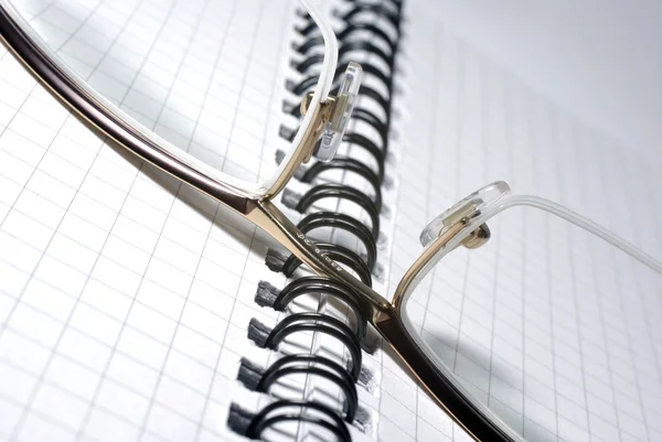 Glasses laying on spiral notebook. Office concept. — Stock Photo, Image