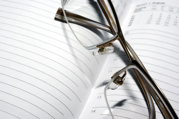 Glasses laying on agenda organizer. Business concept. — Stock Photo, Image