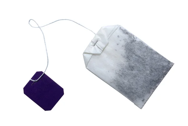 Saco de chá com etiqueta violeta isolada em branco. O caminho de recorte inclui — Fotografia de Stock