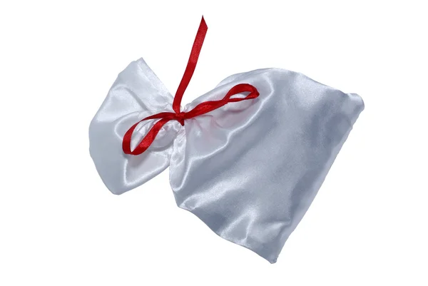 赤いリボンが付いているギフトのための白い絹のバッグ。白で隔離されます。cli — ストック写真