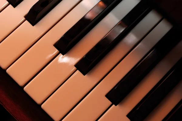 Klaviertasten schließen mit warmem Fotofilter. Spiel mit dem Licht. — Stockfoto