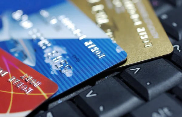 Credit cards laying on laptop keyboard close up photography.