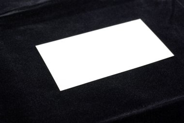 White business card isolated on black velvet background. Empty s clipart