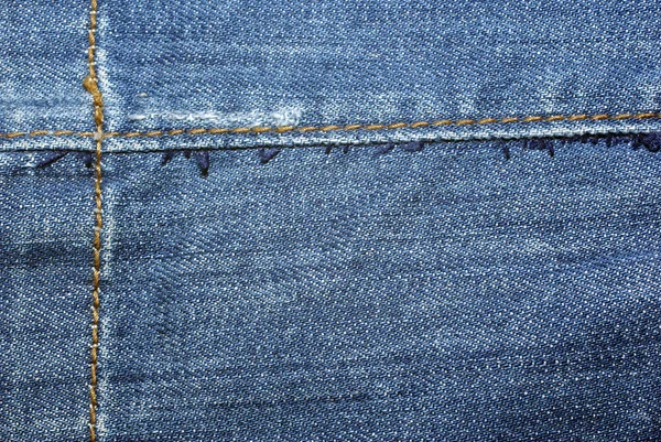 Blauwe versleten jeans met gele steken close-up. achtergrond of bac — Stockfoto