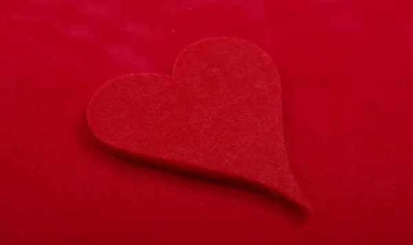 Close up studio shot of heart object isolated on red background. — Stock Photo, Image