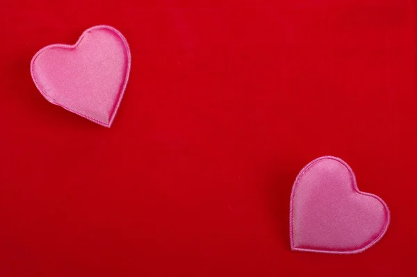 Two pink hearts isolated on red textured background. Empty space — Stock Photo, Image