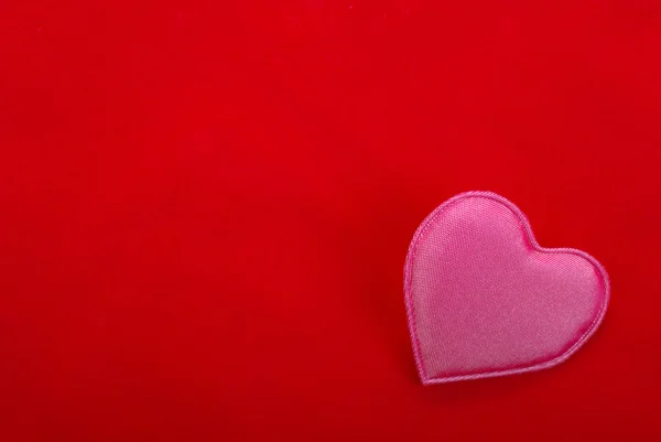 Růžové srdce izolovaných na červeném pozadí. prázdný prostor pro vaše desg — Stock fotografie