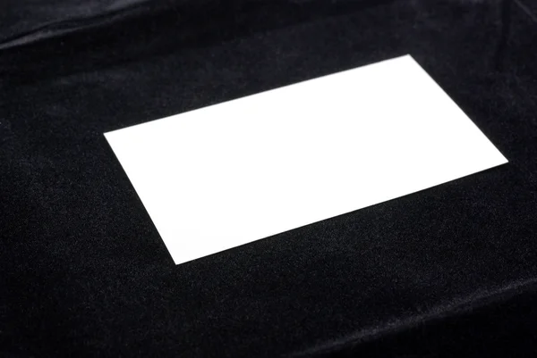 Biała wizytówka na białym tle na tle czarnego aksamitu. pusty s — Zdjęcie stockowe