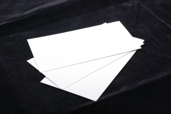 Τρεις λευκοί επαγγελματικές κάρτες που απομονώνονται σε φόντο μαύρο βελούδο. — Φωτογραφία Αρχείου