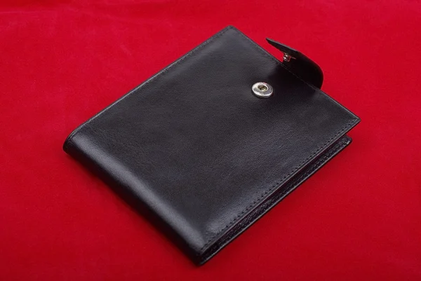 Černá kožená peněženka izolovaných na červeném pozadí. Studio záběr — Stock fotografie