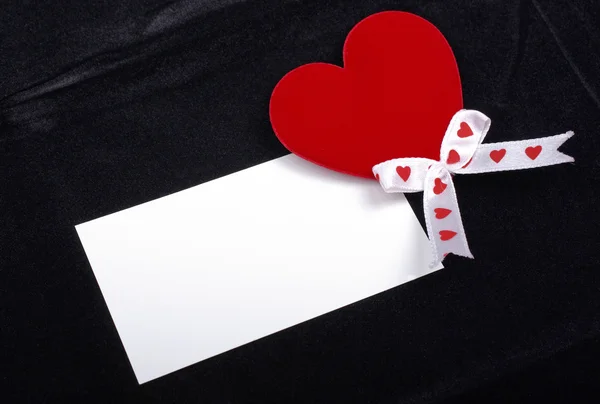Coração vermelho e cartão branco macro isolado no backgrou de veludo preto — Fotografia de Stock