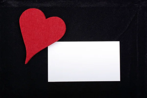 Coração vermelho e cartão vazio isolado em fundo de veludo preto. Em. — Fotografia de Stock