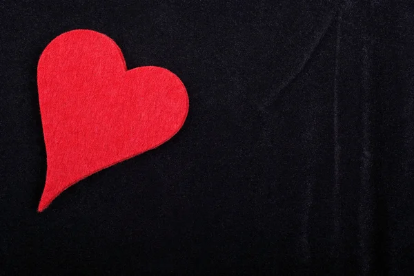 Red heart isolated on black velvet textured background. Empty sp — Stock Photo, Image