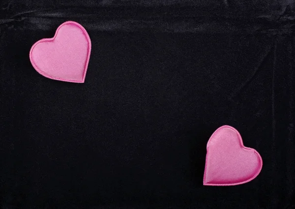 Dois corações cor-de-rosa isolados em fundo de veludo preto. Espaço vazio. — Fotografia de Stock