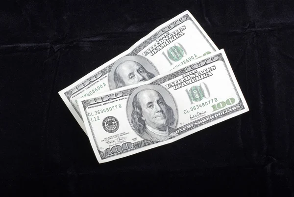 Банкноты по двести долларов, выделенные на черном бархате — стоковое фото