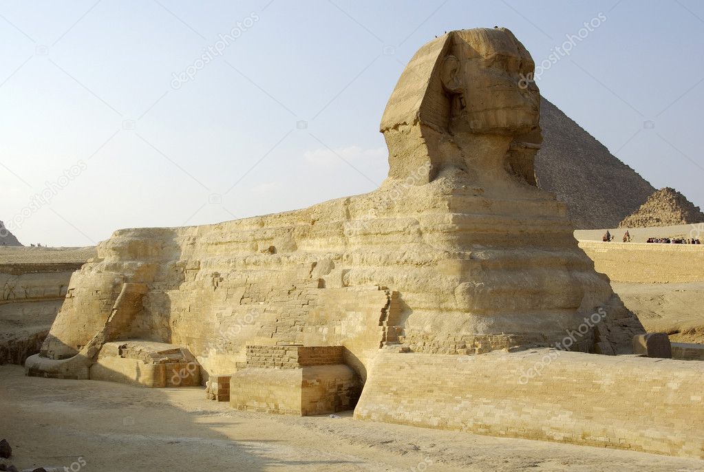 Majestic Sphinx and one of Gizah pyramids in Cairo, Egypt.