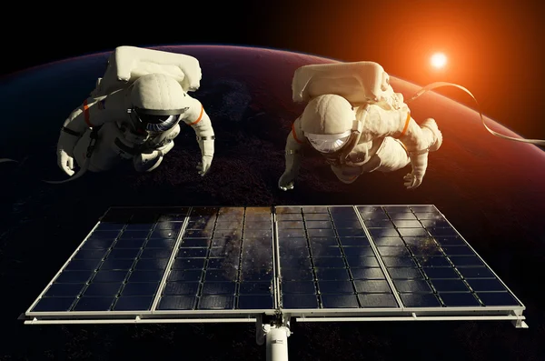 Космонавты в космосе вокруг солнечных батарей — стоковое фото