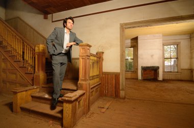 eski bir evde merdivenlerde oturan adam