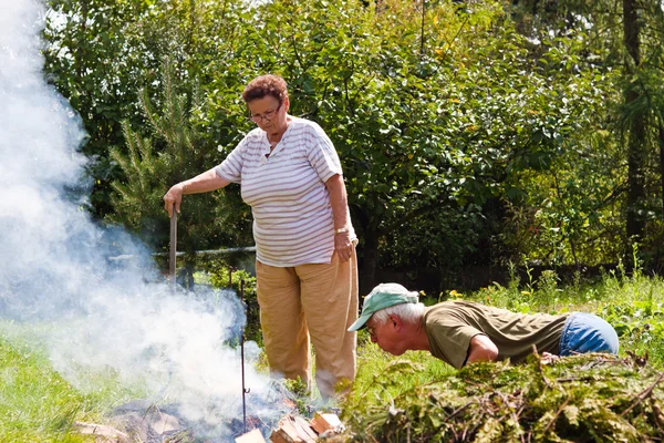 Casal sênior fazendo uma fogueira — Fotografia de Stock