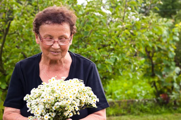 Senior woman with flowers — Stock Photo, Image