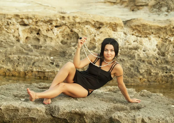 Сексуальные женщины в воде возле скал — стоковое фото