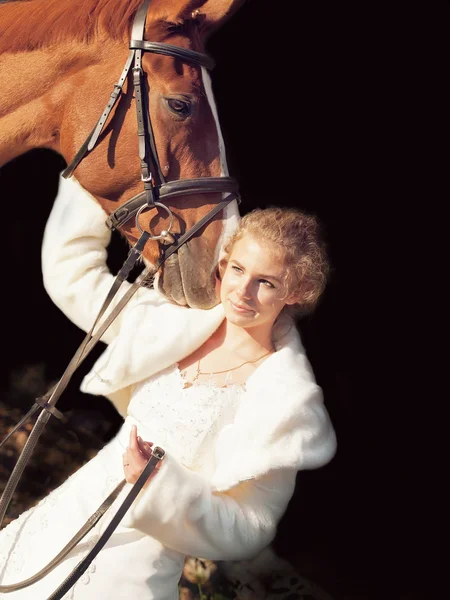 Noiva agradável com cavalo no fundo escuro — Fotografia de Stock