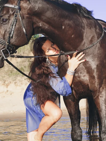 Hübsche Frauen mit schwarzem Pferd im Wasser — Stockfoto