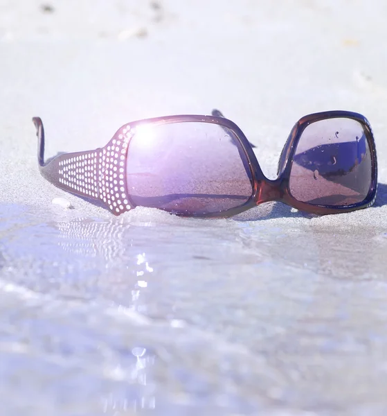 Módní sluneční brýle na písku — Stock fotografie