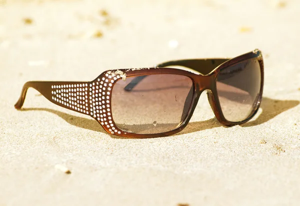 Módní sluneční brýle na písku — Stock fotografie