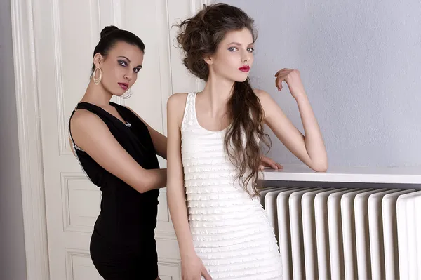 Meisjes in zwart-wit jurken met verbazingwekkende houdingen op de galle — Stockfoto