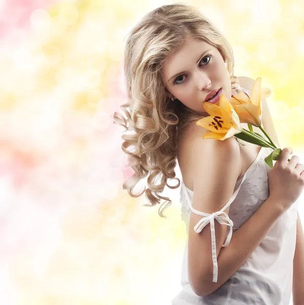 Blond lockig kvinna anläggning lily — Stockfoto