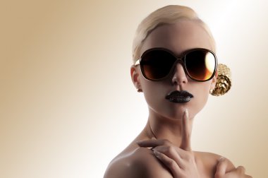 Fashion shot of blond girl with golden sunglasses clipart