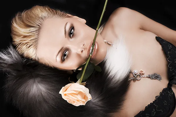 Hübsche Blondine mit einer Rose im Mund — Stockfoto