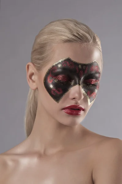 Mooie blonde met carnaval masker geschilderd op gezicht — Stockfoto