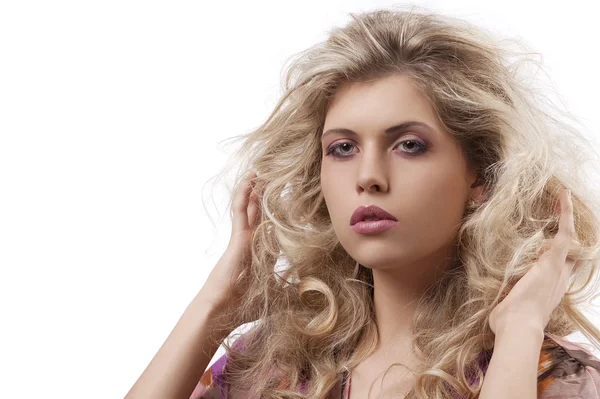 Schöne Frau mit langen lockigen blonden Haaren posiert in Richtung Kamera — Stockfoto