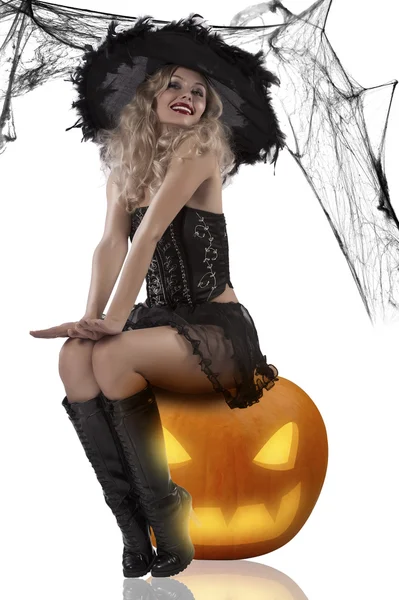 Sexy witch sitting on a pumpkin — Stock Photo, Image
