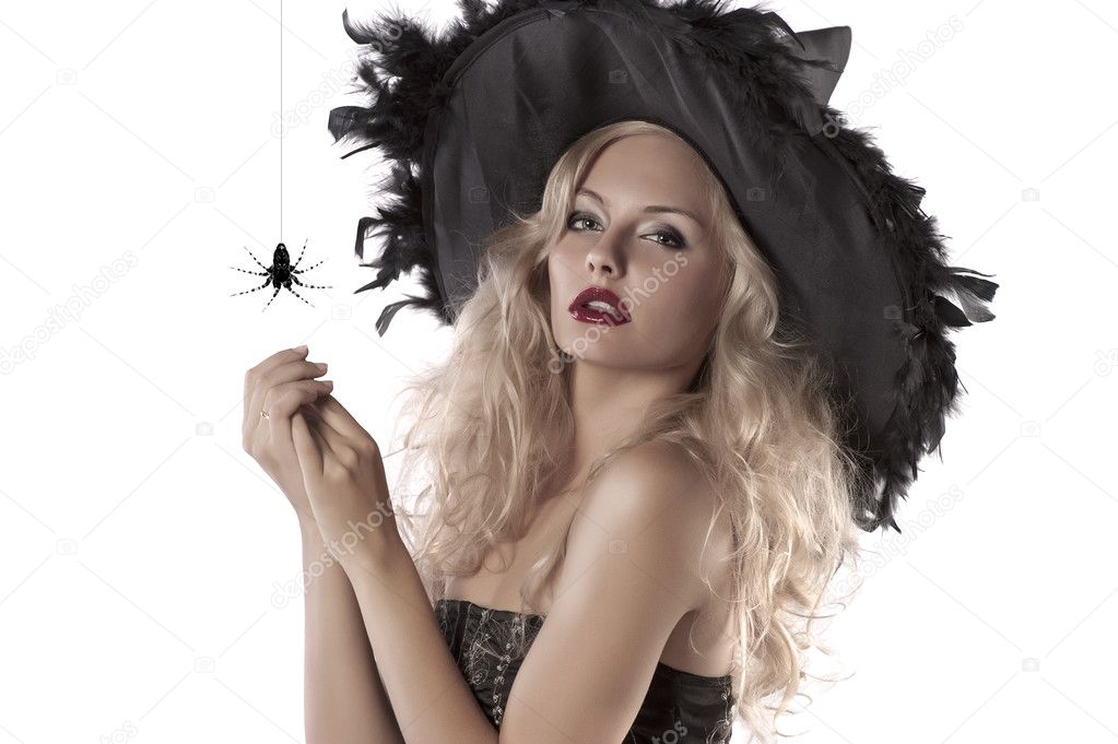 Portrait of beautiful witch wearing a huge hat