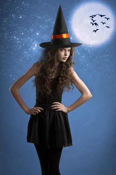 Sweet halloween witch posing under the stars — Stockfoto