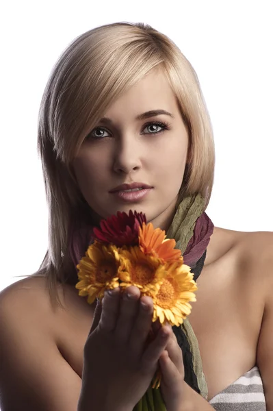 Ładna blondynka trzymając pomarańczowe kwiaty czerwone — Zdjęcie stockowe