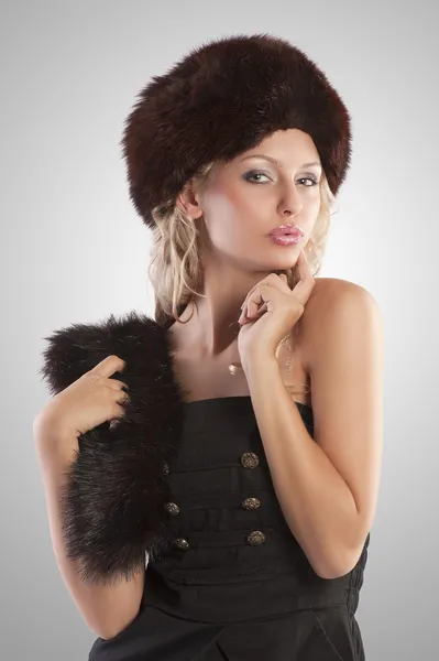 Chica rubia con sombrero de piel en expositor de fondo — Stok fotoğraf